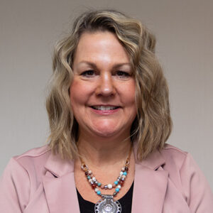 Headhsot of woman with short, wavy blonde hair