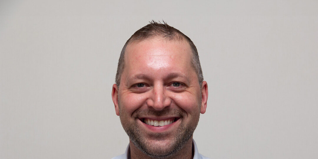 Nate-Roberts-Featured-Image Headshot of man with button up shirt smiling at the camera
