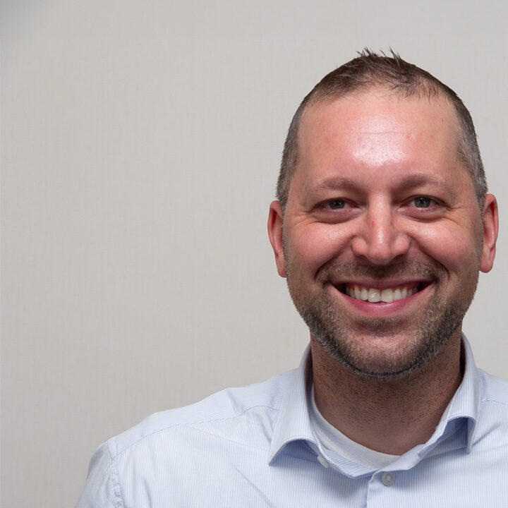Nate-Roberts-Featured-Image Headshot of man with button up shirt smiling at the camera