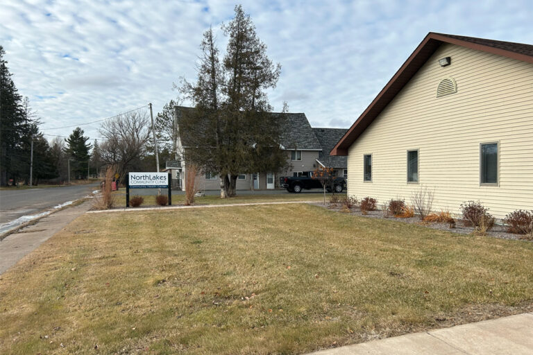 Yard with NorthLakes sign in it and beige colored building