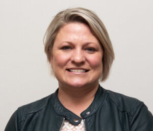 Woman with black leather jacket and short blonde hair