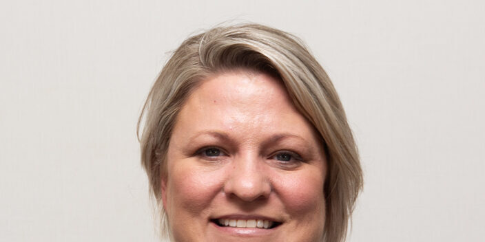 Woman with black leather jacket and short blonde hair