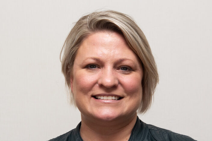 Woman with black leather jacket and short blonde hair