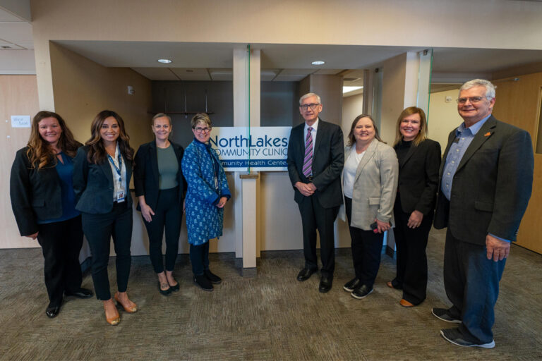 Group of people including Tony Evers smiling and posing for the camera
