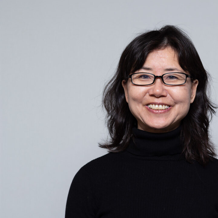 Michaela-Tong-Featured-Image Headshot of woman with shoulder length black hair, black glasses, and black turtleneck