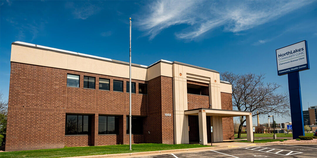 Eau-Clairemont-Avenue-Clinic-Featured-Image Outside of large brick building with flag pole and tall NorthLakes sign out front