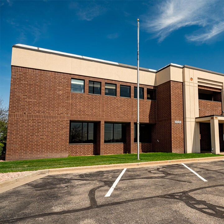 Eau-Clairemont-Avenue-Clinic-Featured-Image Outside of large brick building with flag pole and tall NorthLakes sign out front