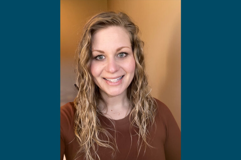 Selfie of woman with blonde curly hair and brown long sleeve