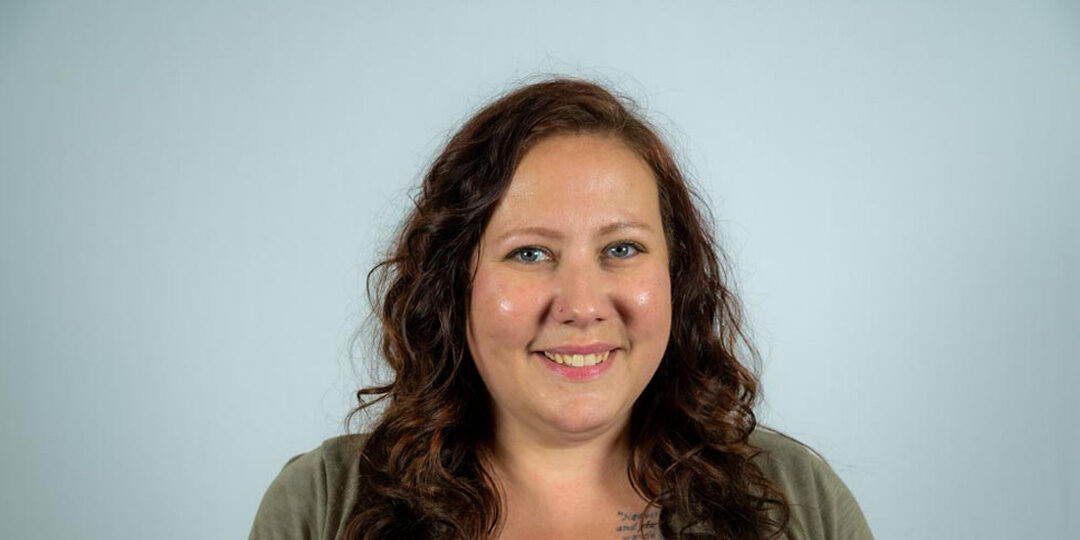 Kate-Christians-Featured-Image Headshot of woman with long curly brown hair smiling