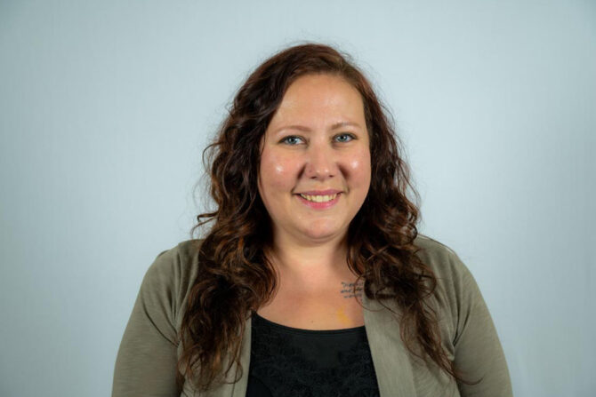 Headshot of woman with long curly brown hair smiling
