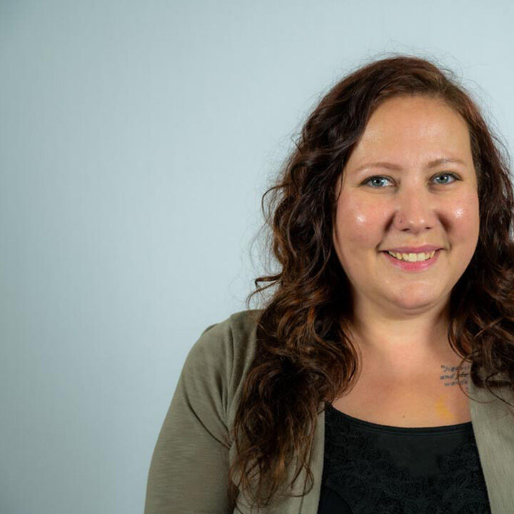 Kate-Christians-Featured-Image Headshot of woman with long curly brown hair smiling