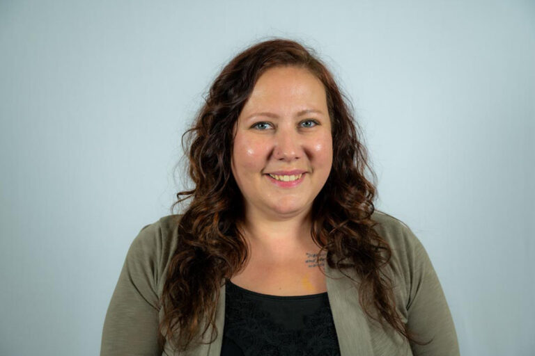 Headshot of woman with long curly brown hair smiling