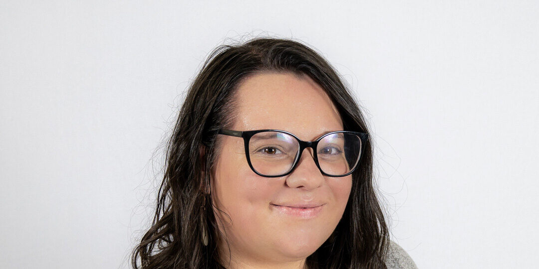 Headshot of woman with short dark hair and glasses