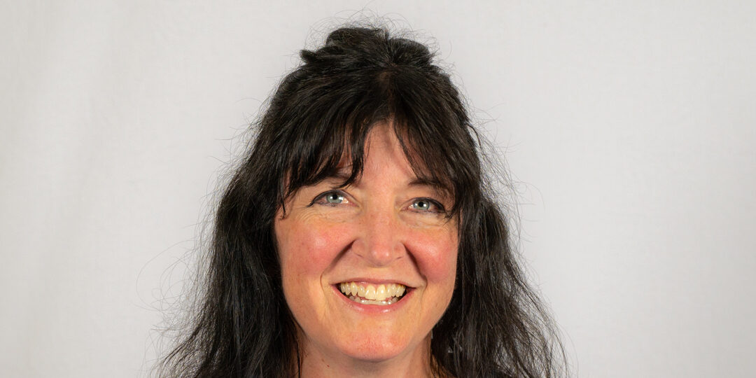 Headshot of woman with dark hair half up