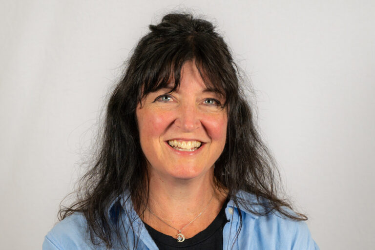 Headshot of woman with dark hair half up