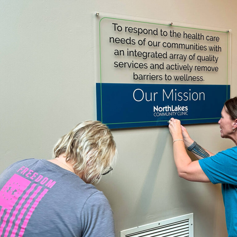 Clinic Move Employees hanging mission sign