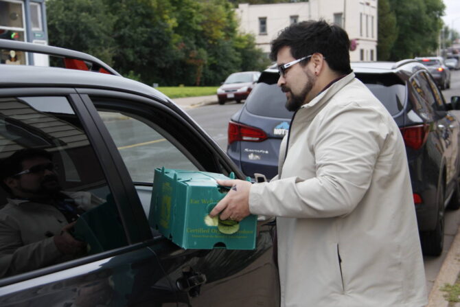 NorthLakes-Farm to Table man handing green food bin through car window