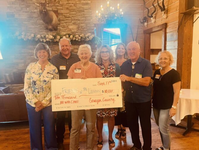 Sawyer Group of men and women holding a check for $10,000