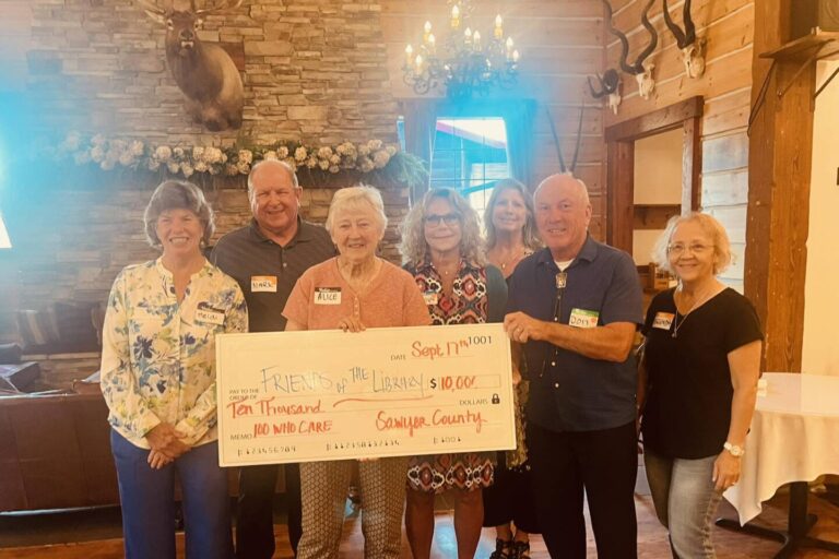Group of men and women holding a check for $10,000
