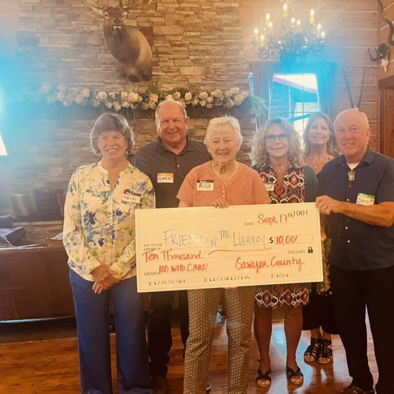 Sawyer Group of men and women holding a check for $10,000