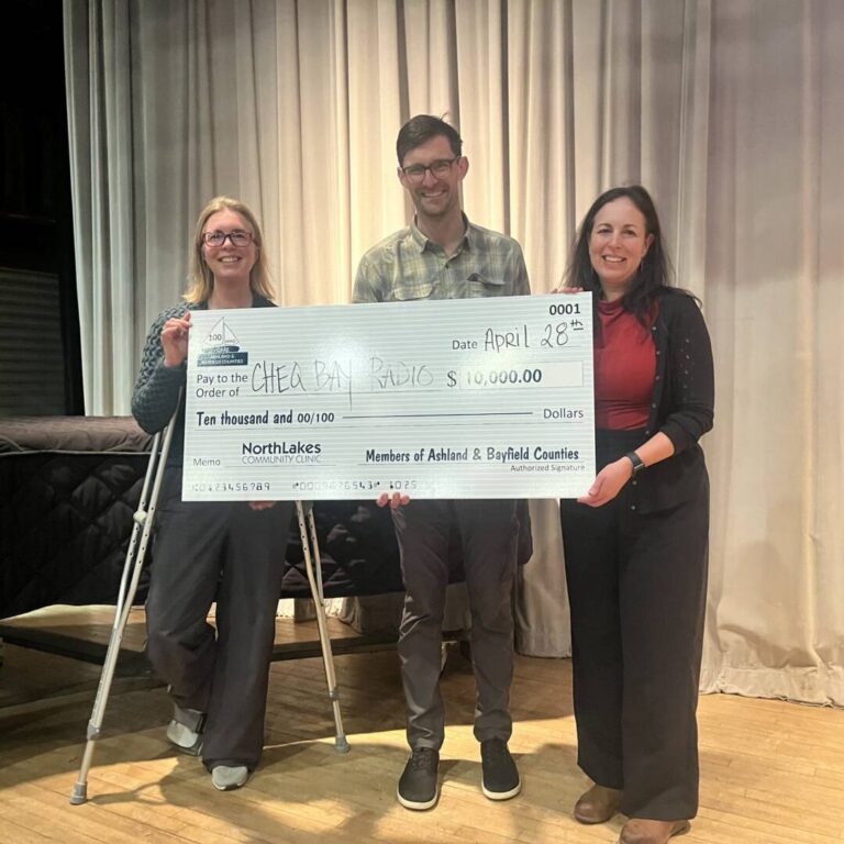 Elizabeth Andre, Dave Ullman and Ana Tochterman three people holding a large check as a donation