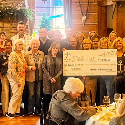 NorthLakes Sawyer Co Giving group photo with people holding large check