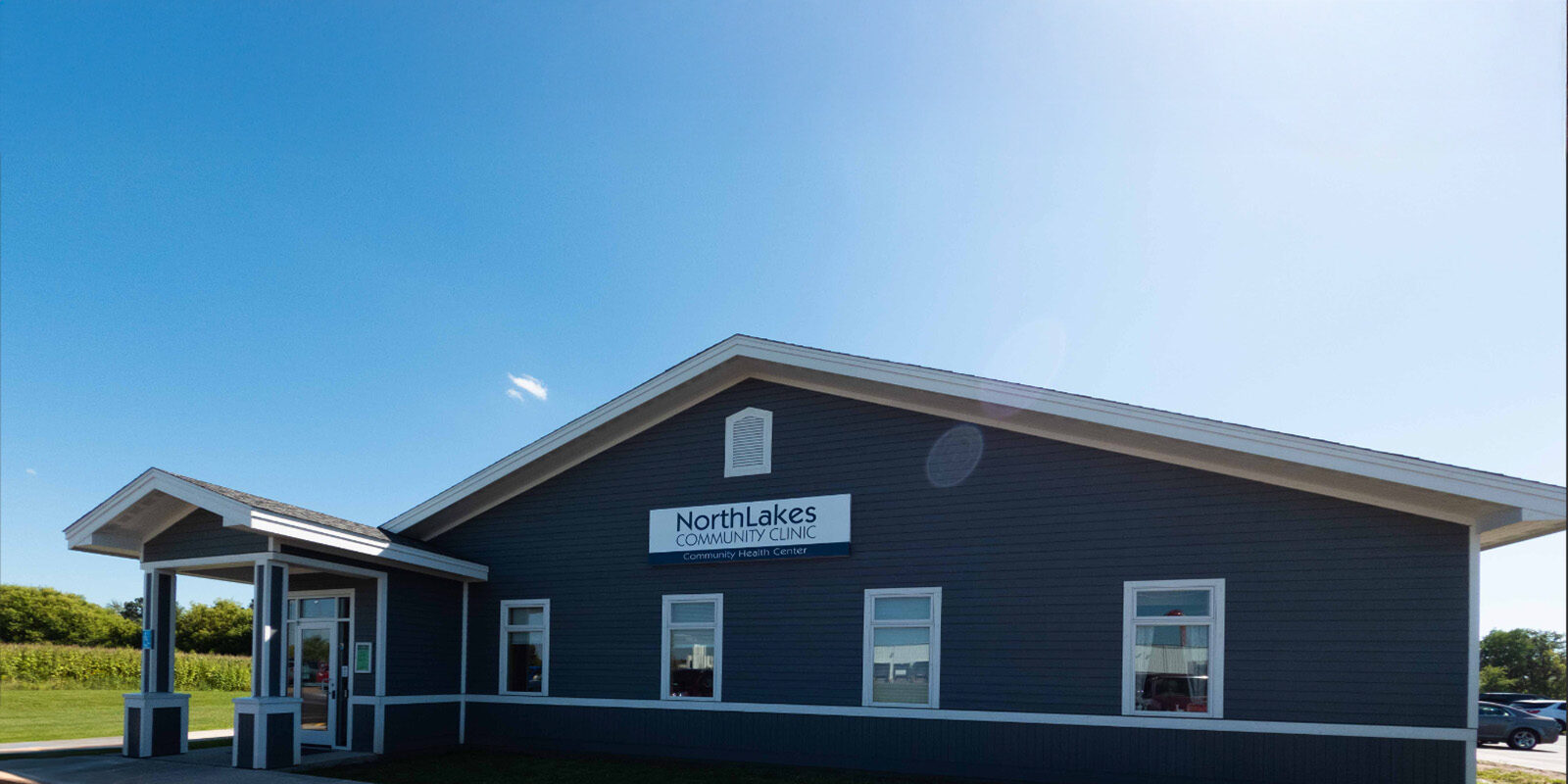 front of a buildig with blue siding and portico entrance.