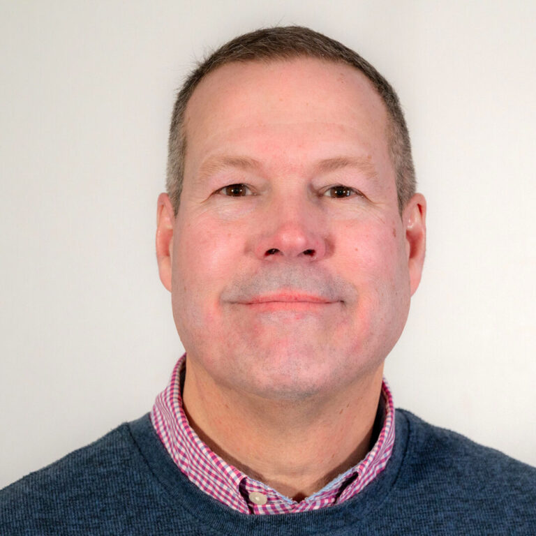 Man with short dark hair and sweater with collar