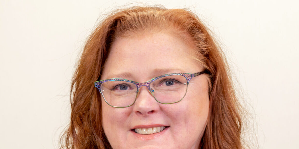 Woman with glasses and blue shirt