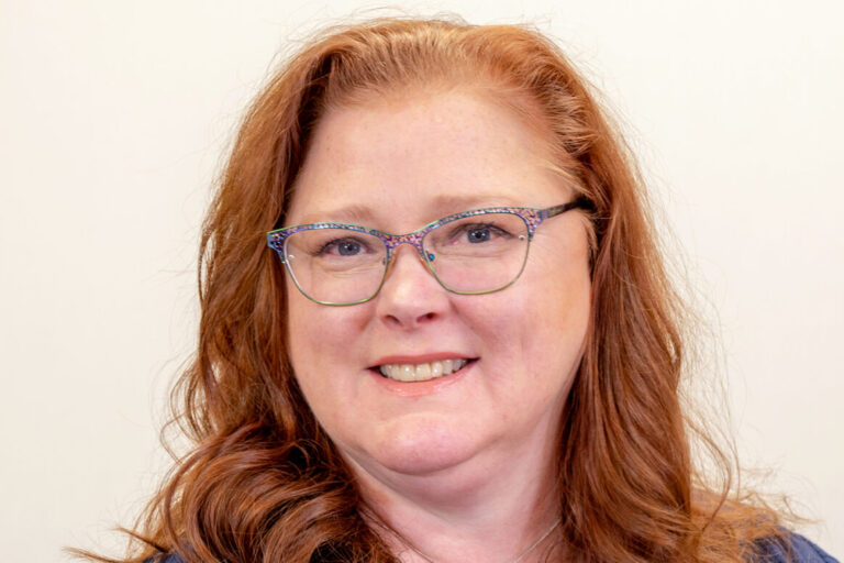 Woman with glasses and blue shirt