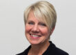 Woman with short blonde hair and black shirt