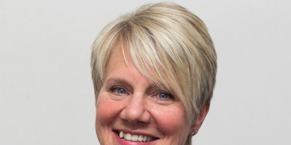 Woman with short blonde hair and black shirt
