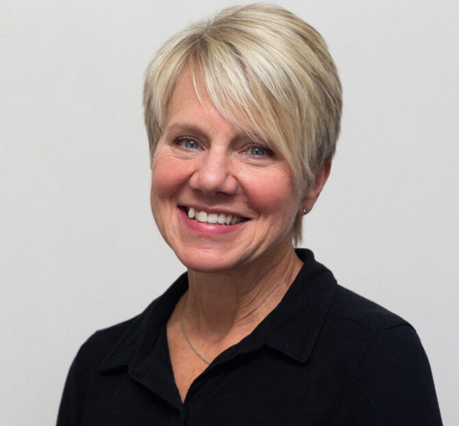 Woman with short blonde hair and black shirt