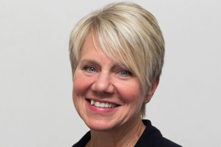 Woman with short blonde hair and black shirt