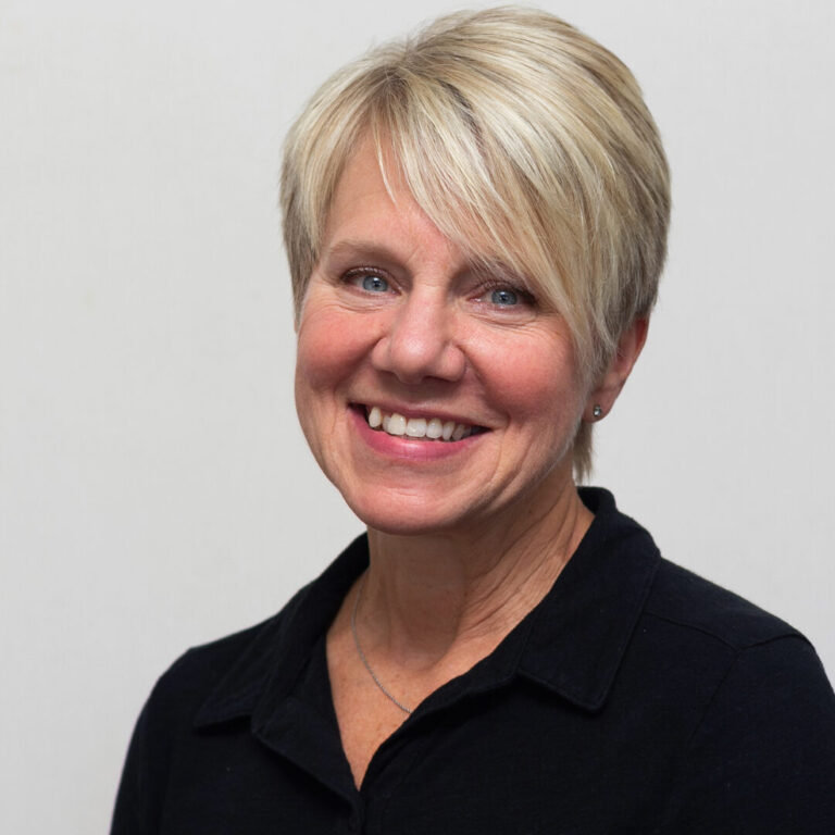 Woman with short blonde hair and black shirt