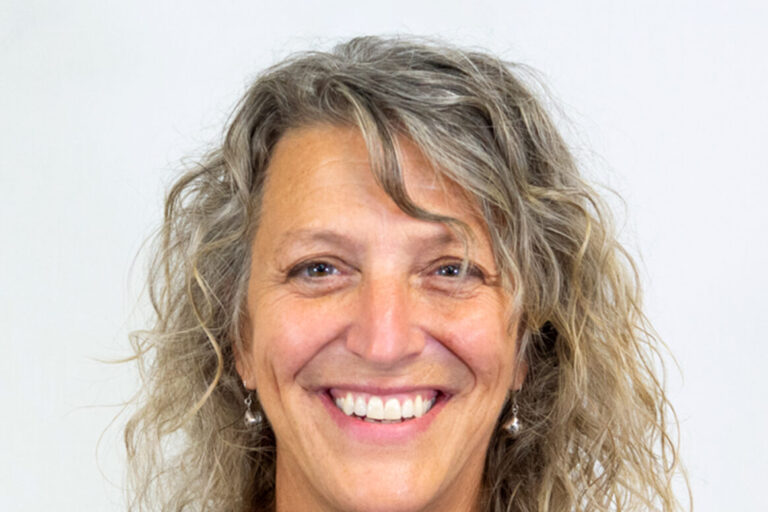 Woman with curly light hair and black tank top
