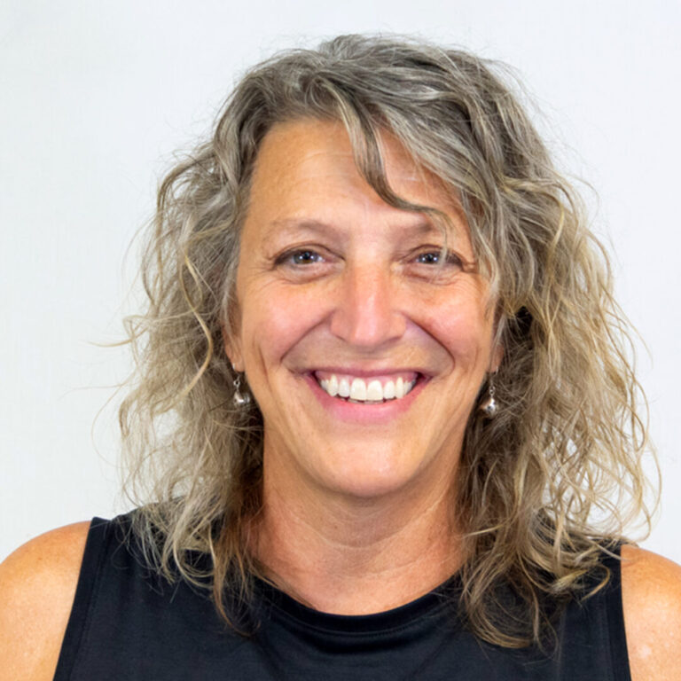 Woman with curly light hair and black tank top