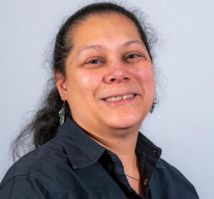 Woman with black ponytail and black polo