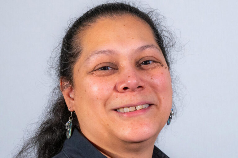 Woman with black ponytail and black polo