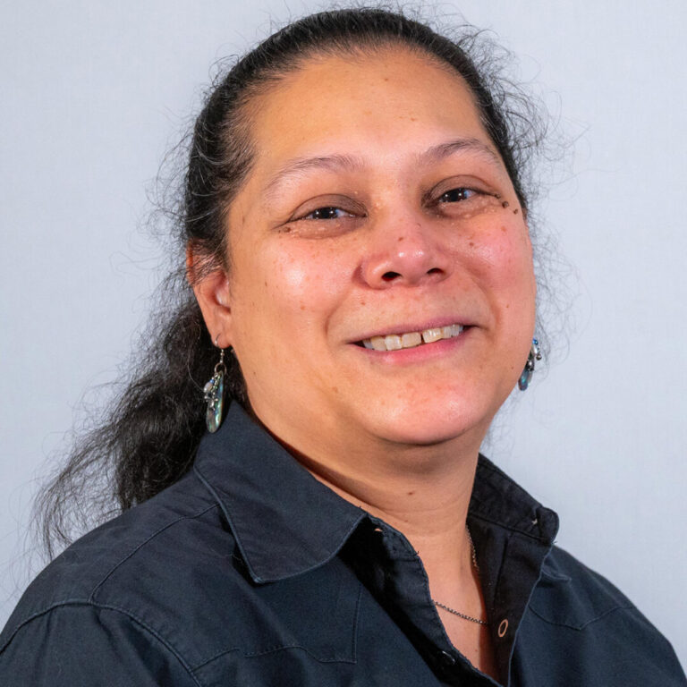Woman with black ponytail and black polo