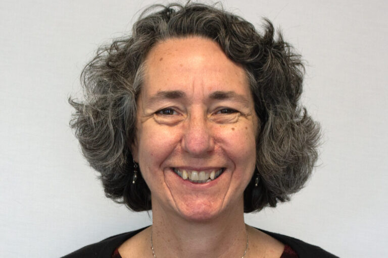 Woman with short hair smiling wearing striped shirt