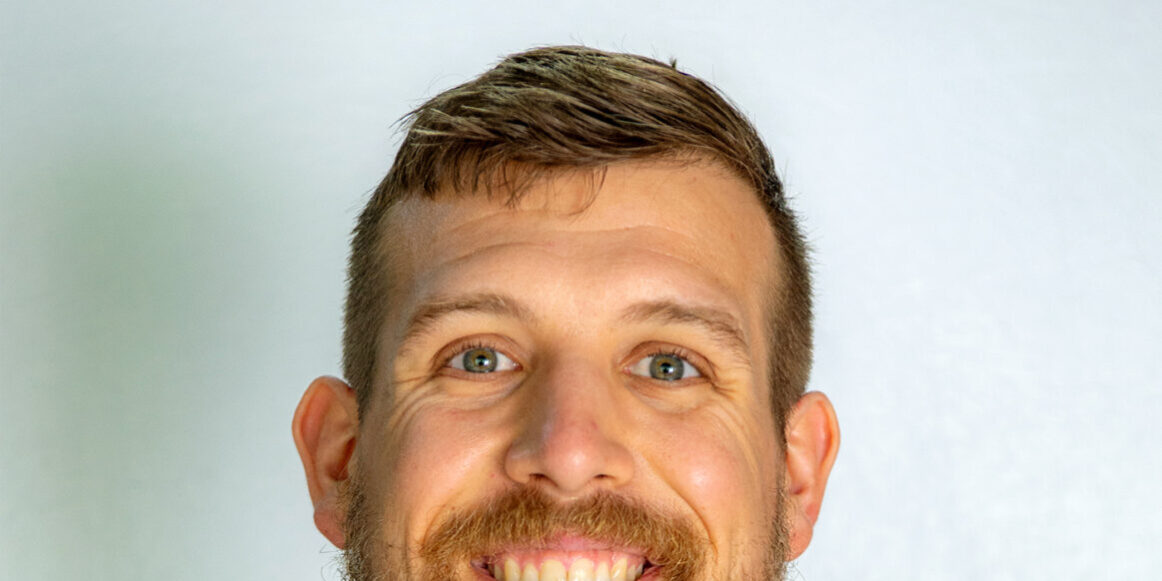 Man with brown short hair and beard