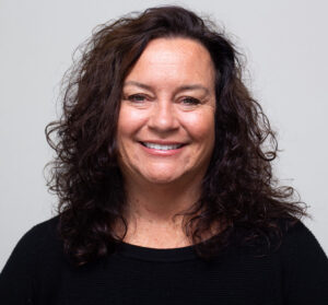 Woman with dark curly hair and black shirt