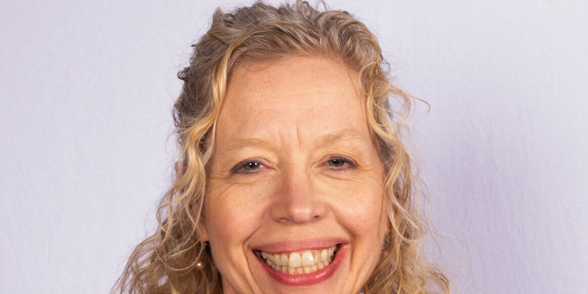 Woman with blonde curly hair and scarf