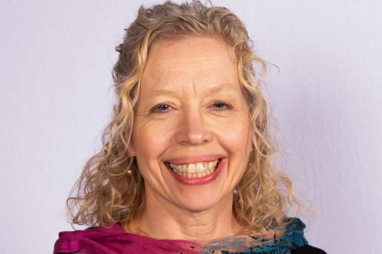 Woman with blonde curly hair and scarf