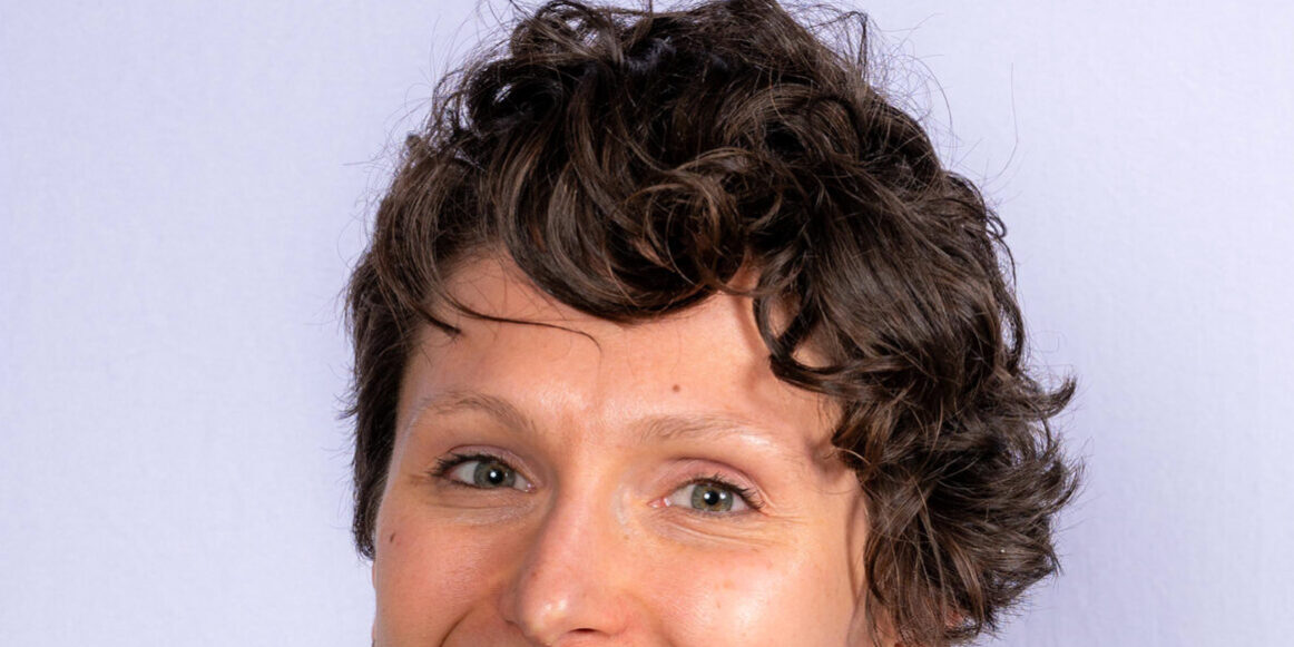 Woman with short curly hair and hazel eyes