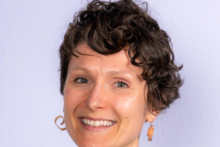 Woman with short curly hair and hazel eyes