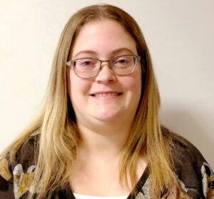 Woman smiling with long blonde hair and glasses