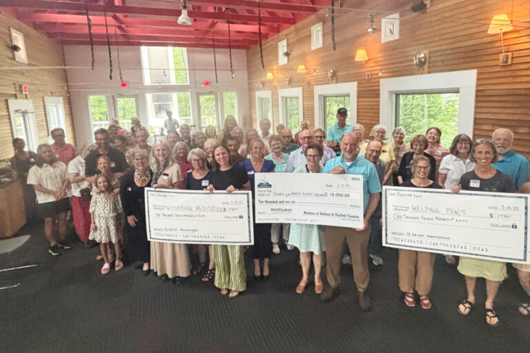 large group of people holding three large checks