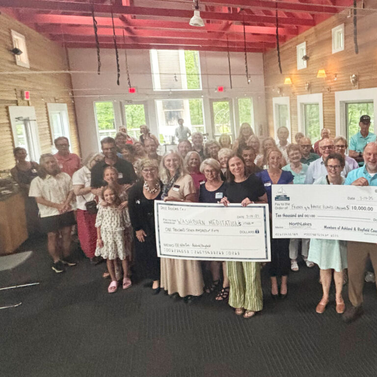 NorthLakes-Ashland-Bayfield-100-who-care large group of people holding three large checks